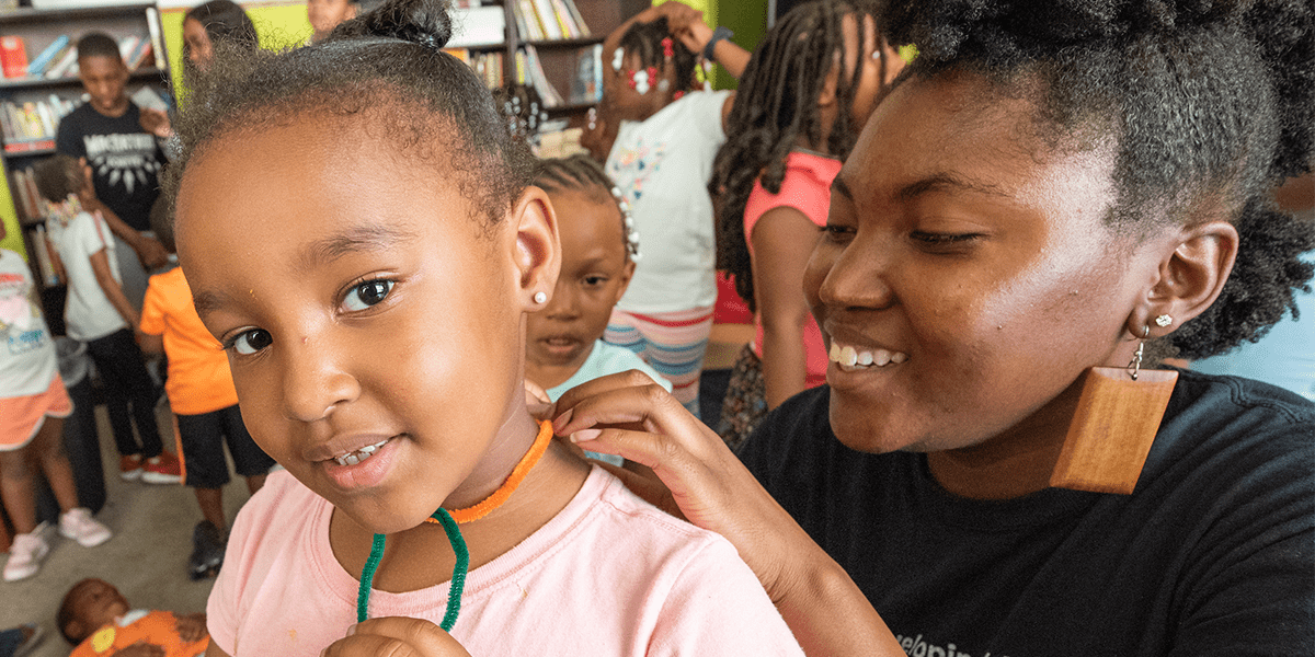 Volunteer and child interact at a summer youth program