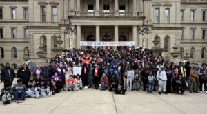 Large group of people outside the capital building with a banner that reads "We are Afterschool!"